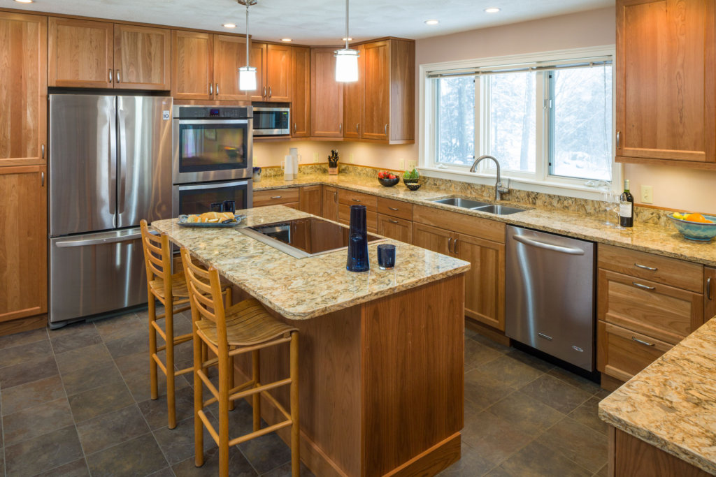 large modern kitchen scene with an island, granite countertops and a stainless steel french door refrigderator