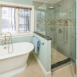 sea green bathroom scene showing a large white tube, tile shower and wintery view out a window