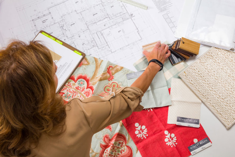 female interior designer working with plans and fabric samples, view from above
