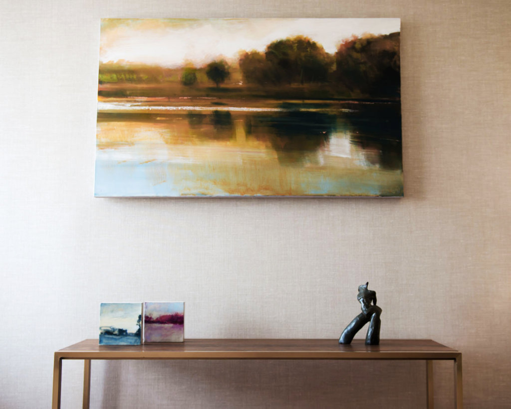water scene painting hanging over a side table, view straight on