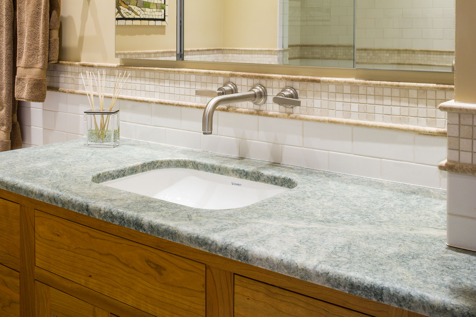 close up of a bathroom sink with a green stone countertop